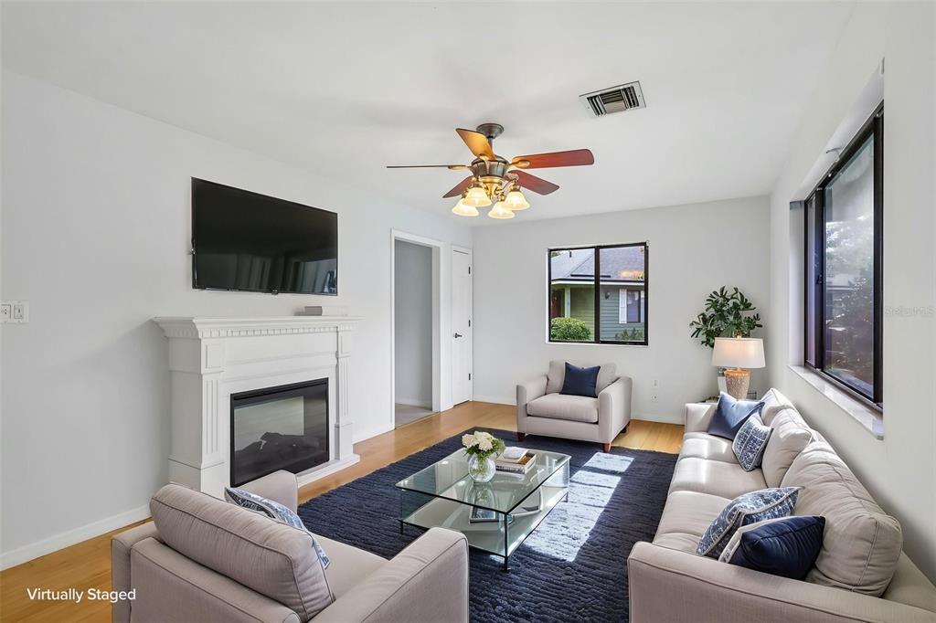 A living room features a fireplace, a ceiling fan, and a dark rug on wood floors — 632 MOUNT HOMER ROAD UNIT 4A, EUSTIS, FL