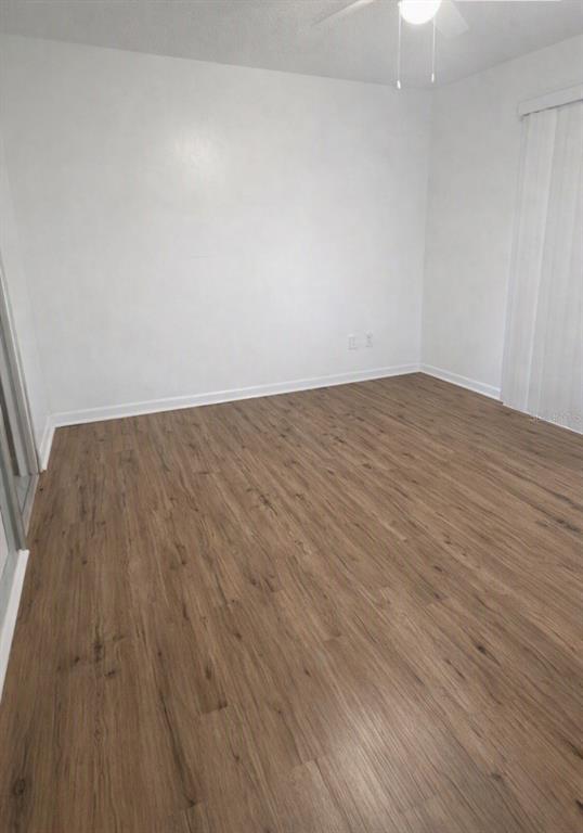An empty room with white walls, wood-look flooring, and a ceiling fan — 1412 PORTOBELLO DRIVE, PORT ORANGE, FL