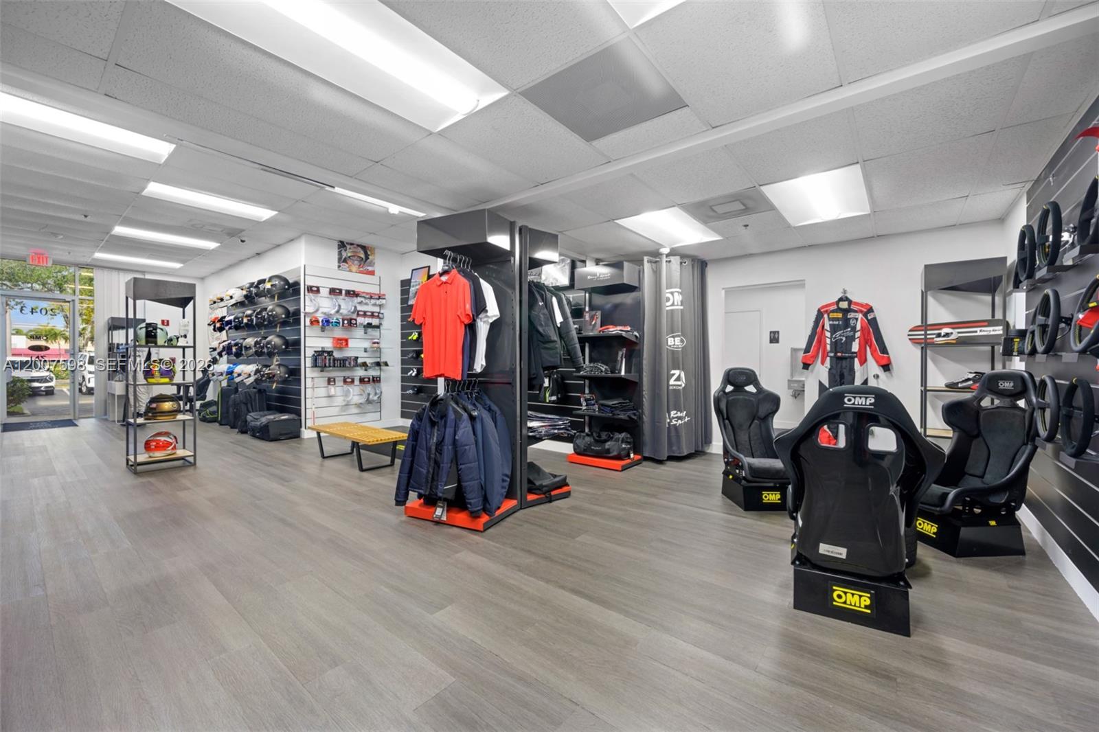 A retail store displays racing gear, including helmets, apparel, and OMP racing seats — DORAL, FL