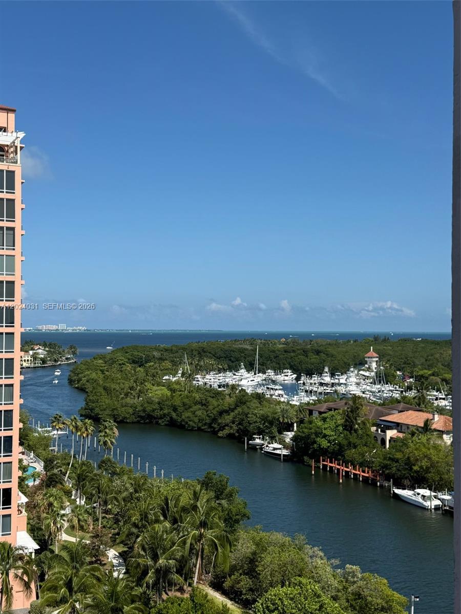 An elevated view shows a marina with many boats nestled among trees near the ocean — 90 Edgewater Dr # 1222, Coral Gables FL 33133, CORAL GABLES, FL