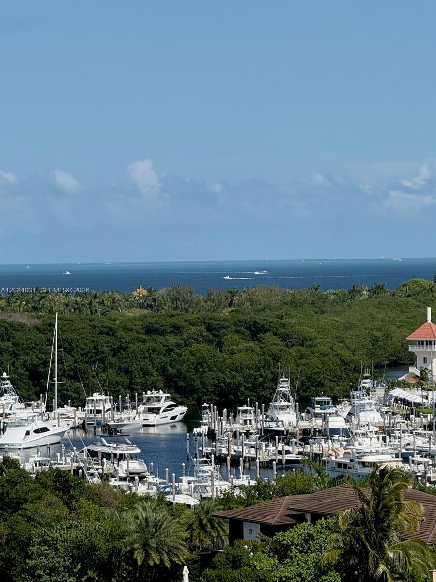 A high-angle view shows a marina filled with yachts surrounded by dense green trees — 90 Edgewater Dr # 1222, Coral Gables FL 33133, CORAL GABLES, FL