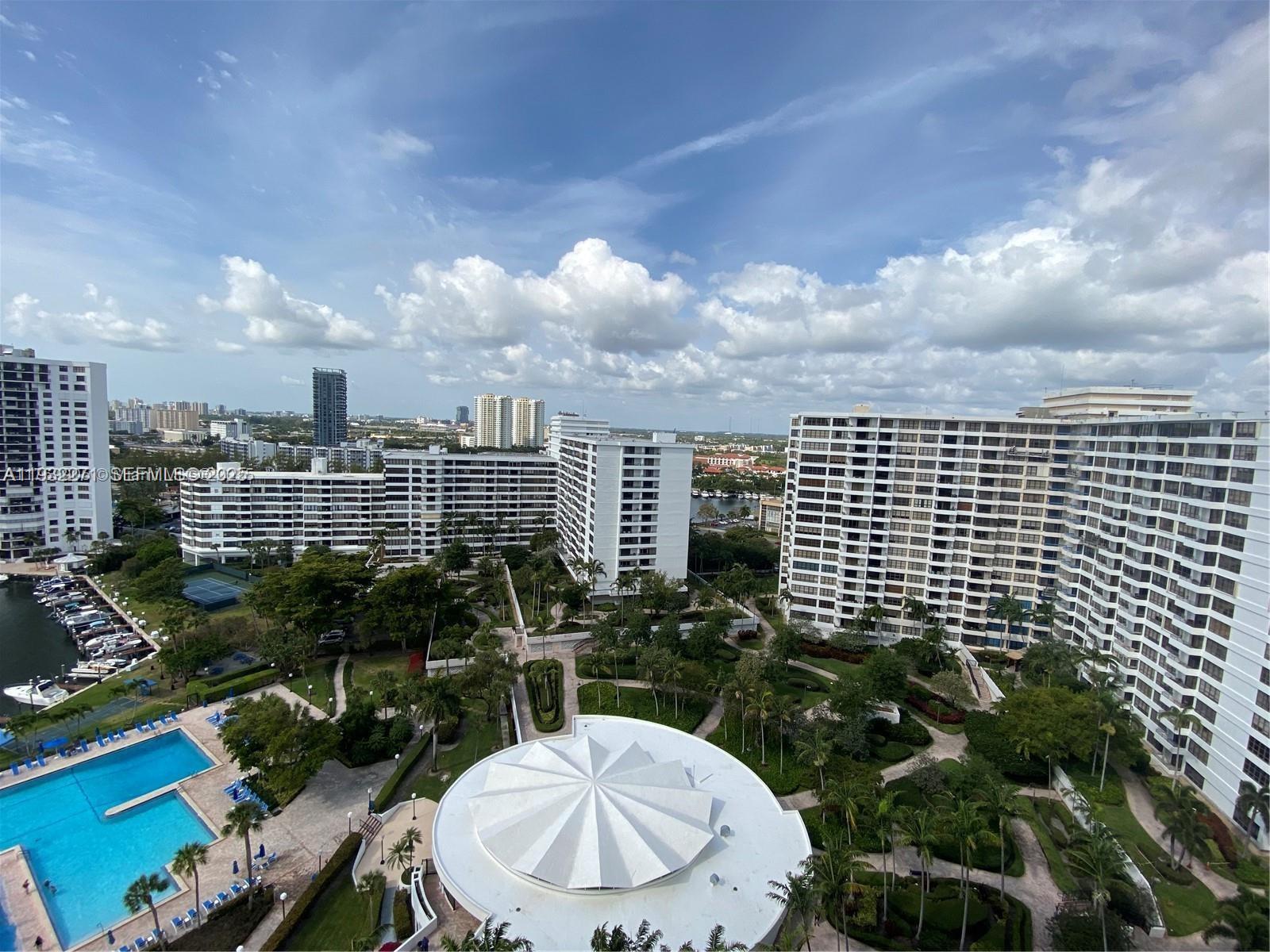 An elevated view shows a residential complex with a pool, landscaped gardens, and tall buildings — 2500 Parkview Dr # 1920, Hallandale Beach FL 33009, HALLANDALE BEACH, FL