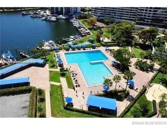 An aerial view shows a swimming pool, patio area, and boat slips along a canal — 2500 Parkview Dr # 1920, Hallandale Beach FL 33009, HALLANDALE BEACH, FL