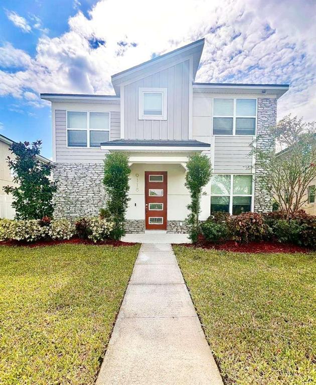 A two-story house with a red front door, stone veneer, and a concrete walkway — 9118 LONGSHIP ALLEY, ORLANDO, FL
