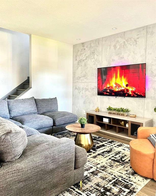 A living room features a grey sectional sofa, a round coffee table, and a wall-mounted television — 9118 LONGSHIP ALLEY, ORLANDO, FL