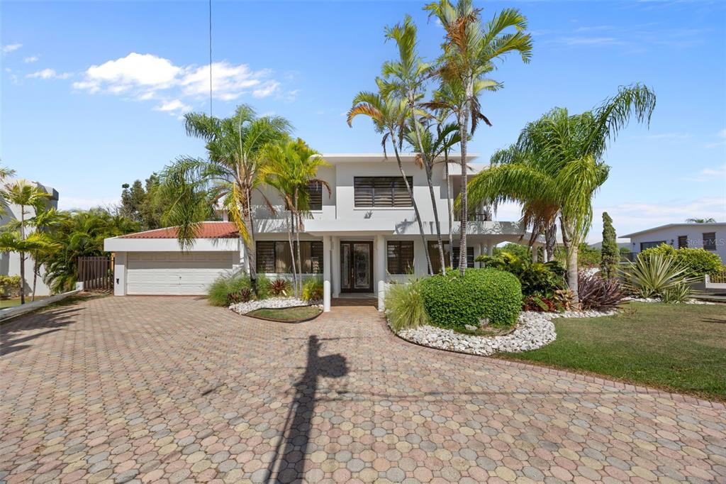A two-story house with a paved driveway, palm trees, and a two-car garage — 3 CARLOTA STREET, GUAYAMA, PR