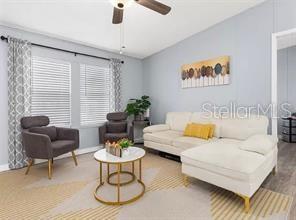 A living room features a white sectional sofa, two gray armchairs, and a round coffee table — 4884 DUNCAN ROAD, PUNTA GORDA, FL
