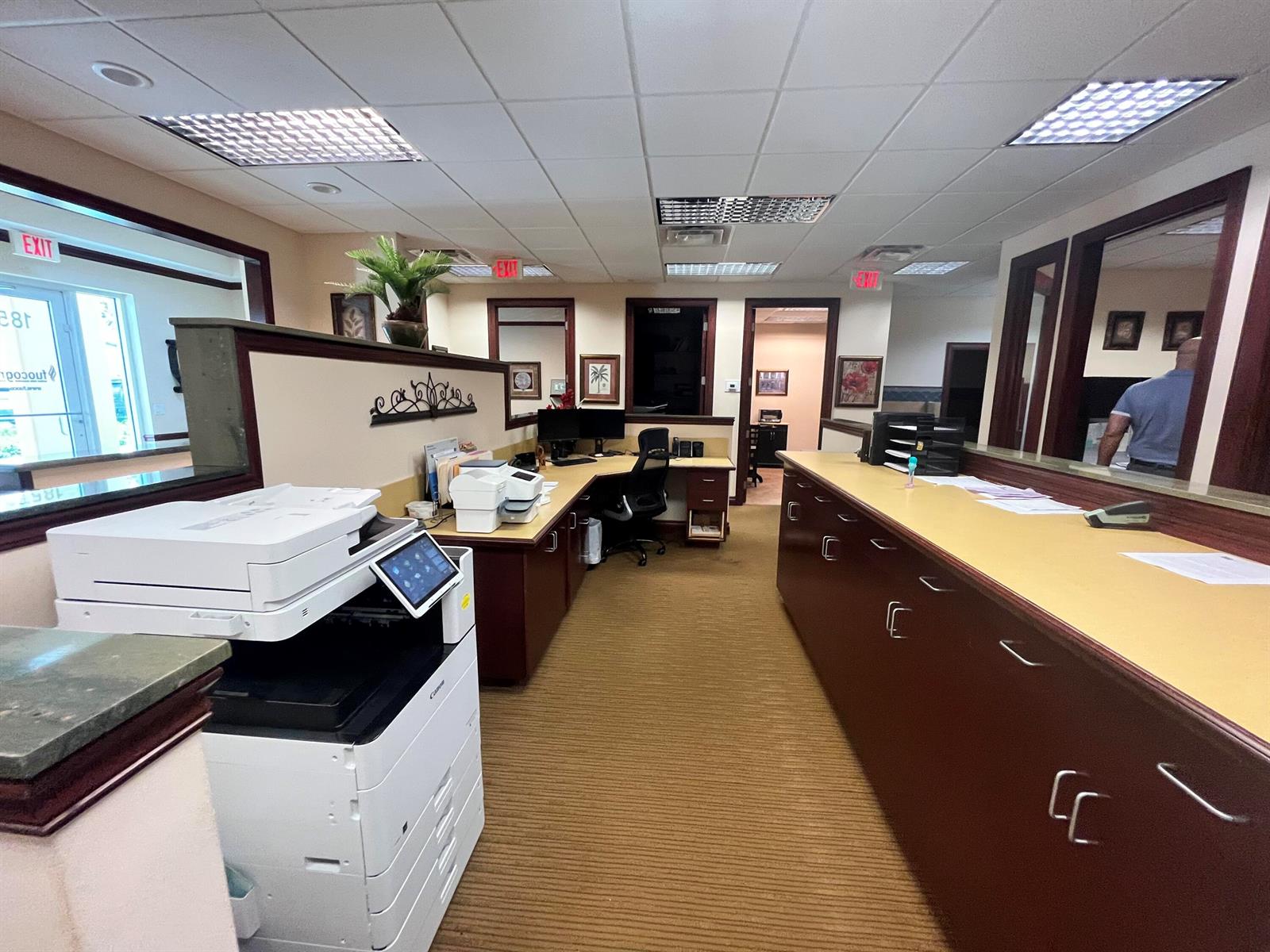An office interior features a large printer, a reception desk, and a workstation with computers — 1857 Banks Road # 1859, Margate FL 33063, MARGATE, FL