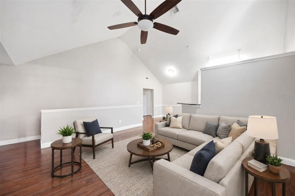 A living room with vaulted ceilings, hardwood floors, a ceiling fan, and neutral furniture — 3364 WESTCHESTER SQUARE BOULEVARD UNIT 202, ORLANDO, FL