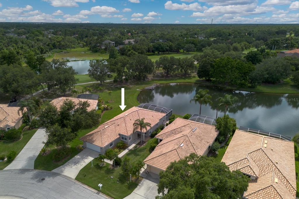 An aerial view shows a single-story house with a tile roof near a pond — 6726 HICKORY HAMMOCK CIRCLE, BRADENTON, FL