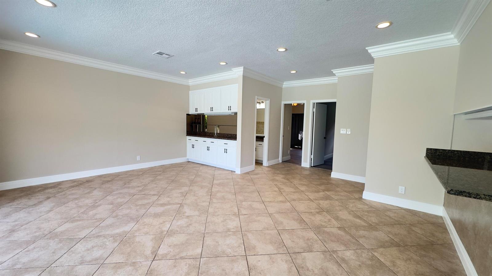 An open living area features tan tile floors, recessed lighting, and sliding glass doors — 11330 Timberlodge Terrace, Boca Raton FL 33428, BOCA RATON, FL