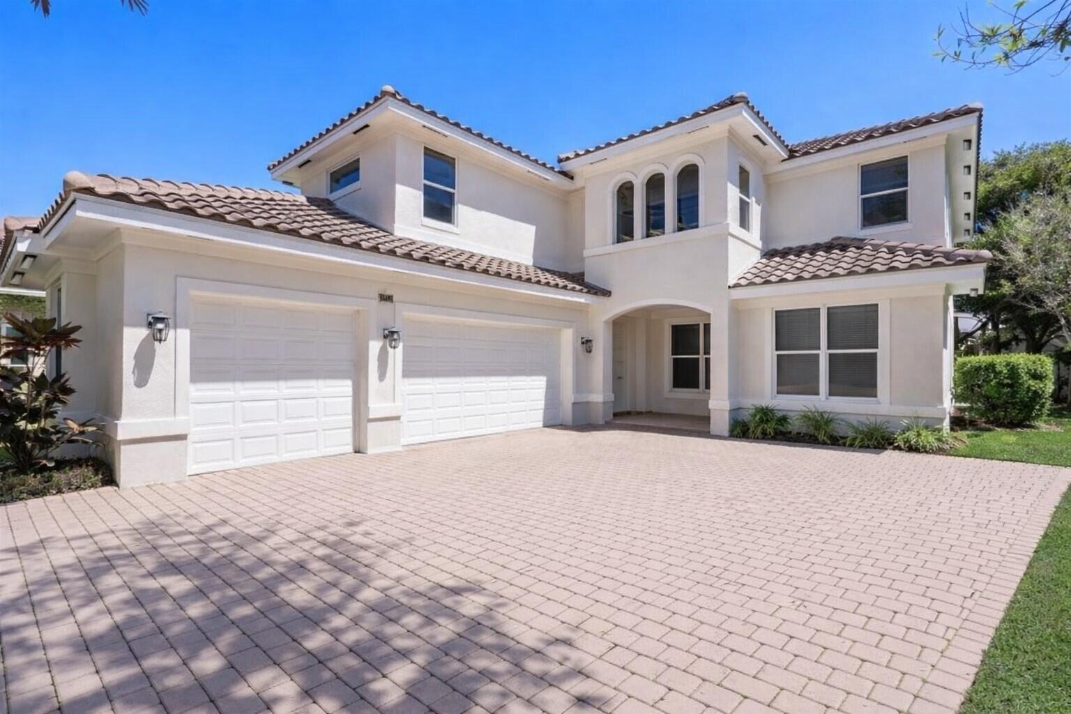 A two-story house with a tiled roof, white stucco exterior, and a paved driveway — 2013 Harbor View Circle, Weston FL 33327, WESTON, FL