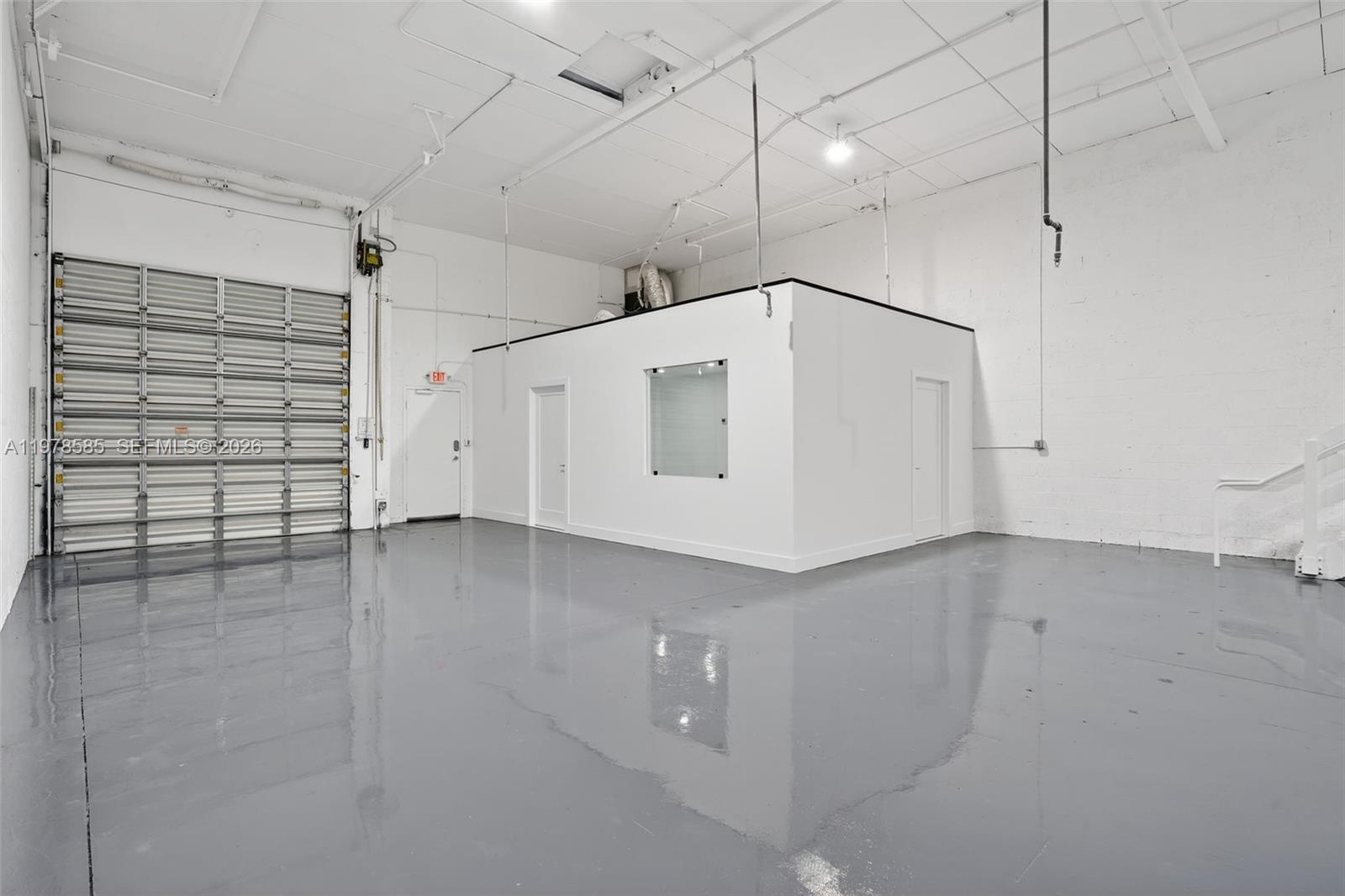 An industrial warehouse space features a gray epoxy floor, white walls, and a central office — 16300 SW 137th Ave # 119, Miami FL 33177, MIAMI, FL