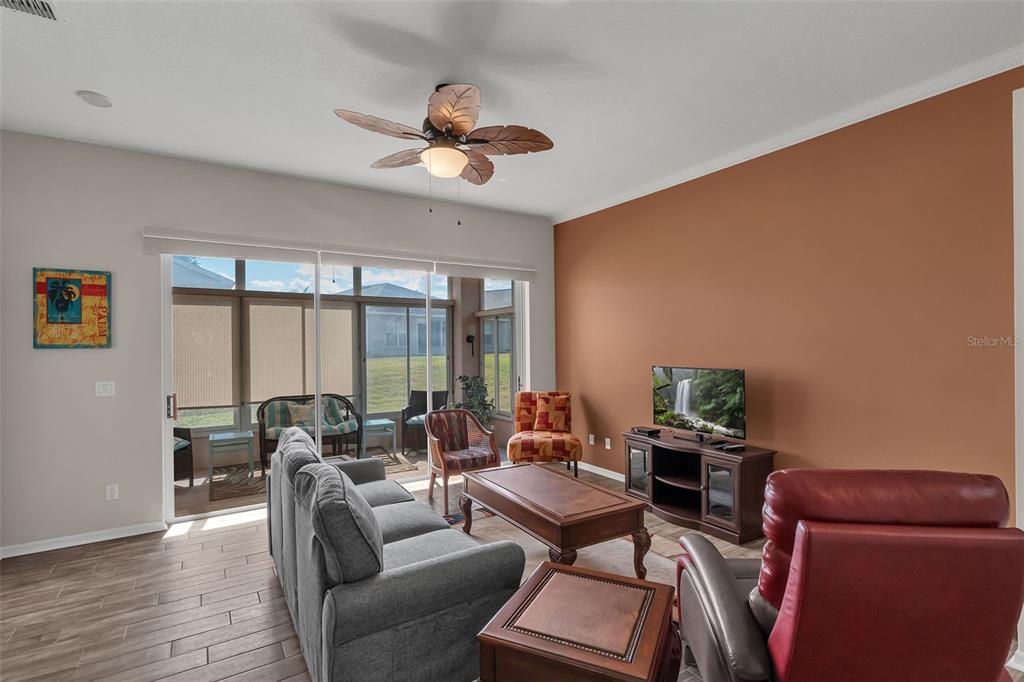 A living room features a gray sofa, a red recliner, and a large terracotta accent wall — 213 HIGH VISTA DR, DAVENPORT, FL