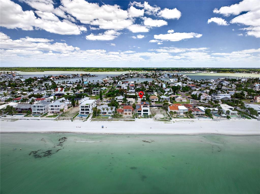 An aerial view shows a beachfront house marked with a red pin on the coast — 16107 GULF BOULEVARD, REDINGTON BEACH, FL