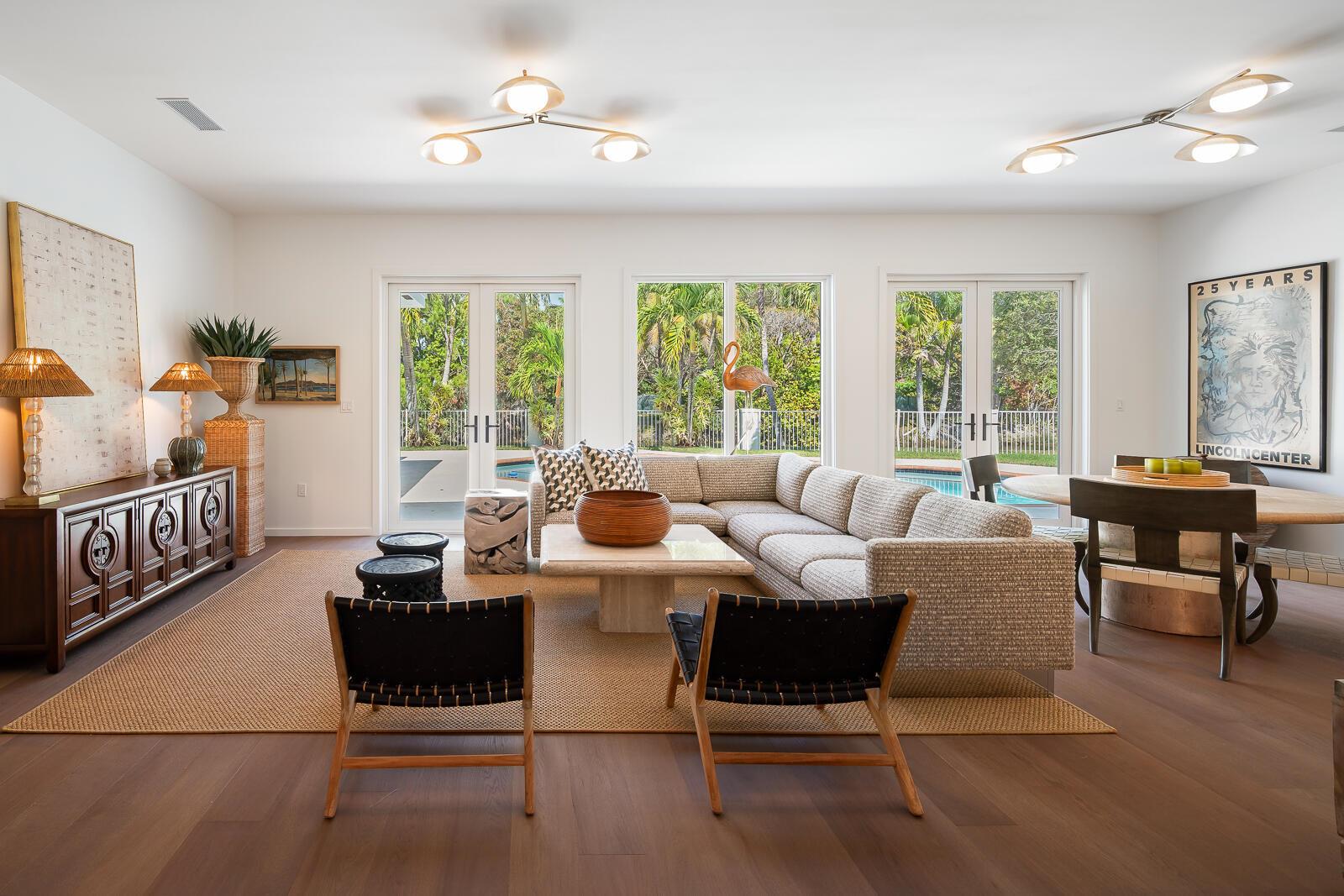 A living room with a sectional sofa, two black chairs, and glass doors to a pool — 6371 SW 87th Terrace, Pinecrest FL 33156, PINECREST, FL
