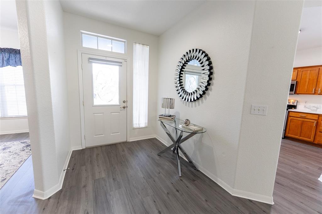 A living room features a grey sofa, glass coffee table, television console, and wood-look flooring — 12855 SE 92ND COURT ROAD, SUMMERFIELD, FL