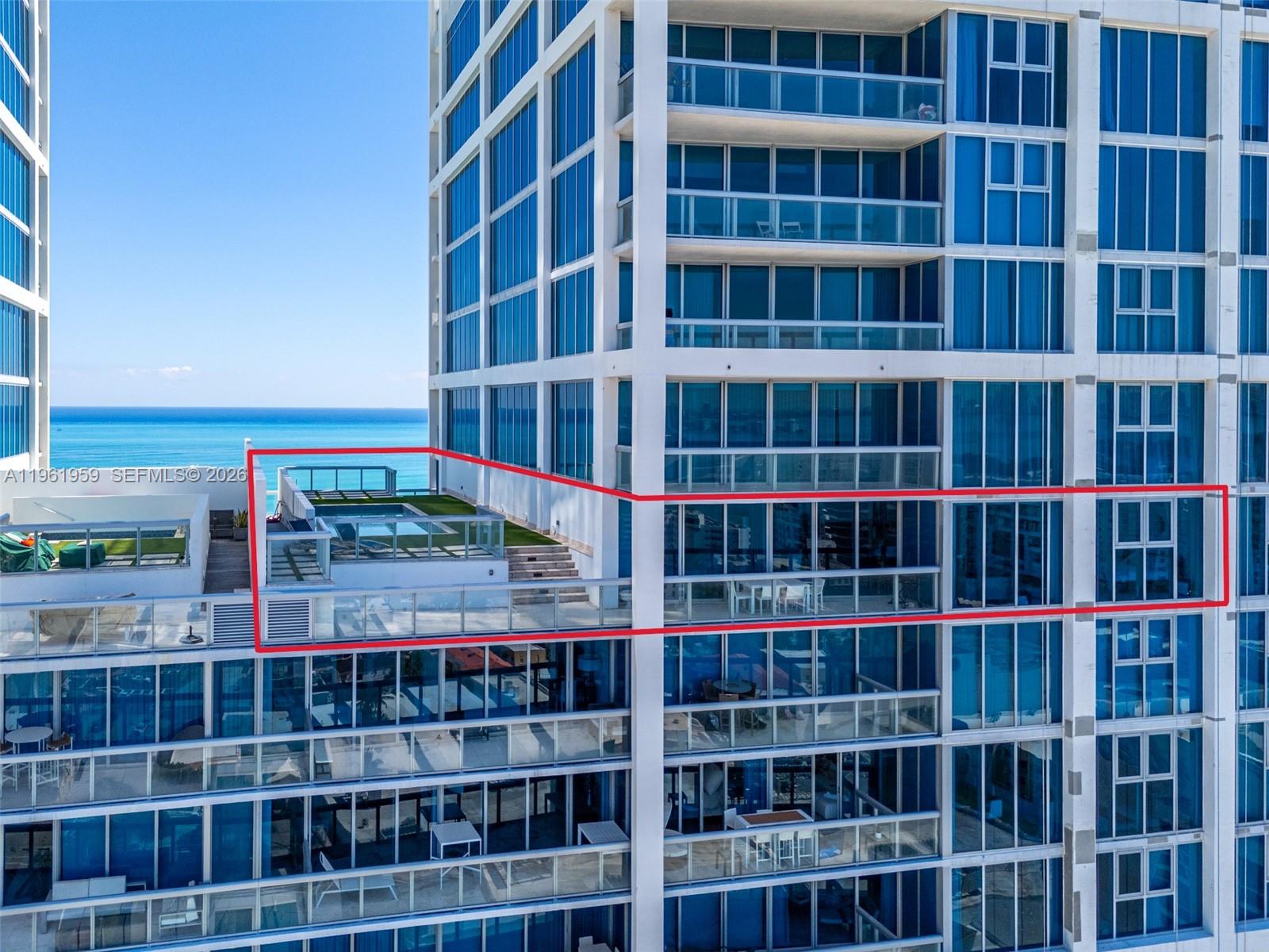 An aerial view shows a high-rise building with a large private terrace featuring a pool — 6899 Collins Ave, Miami Beach FL 33141, MIAMI BEACH, FL