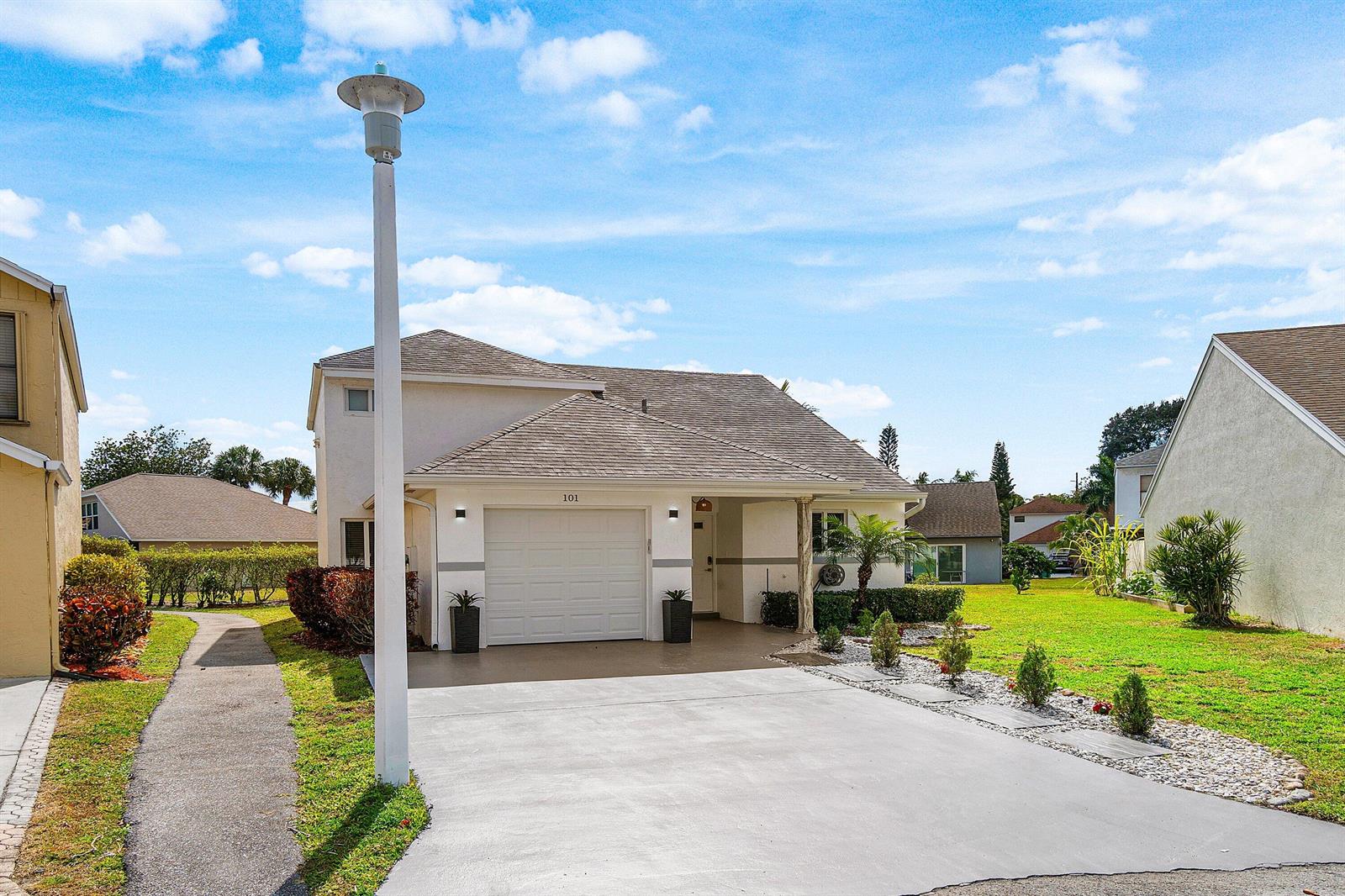 A two-story house with a white garage, a concrete driveway, and a front walkway — 101 Azalea Circle, Boynton Beach FL 33436, BOYNTON BEACH, FL