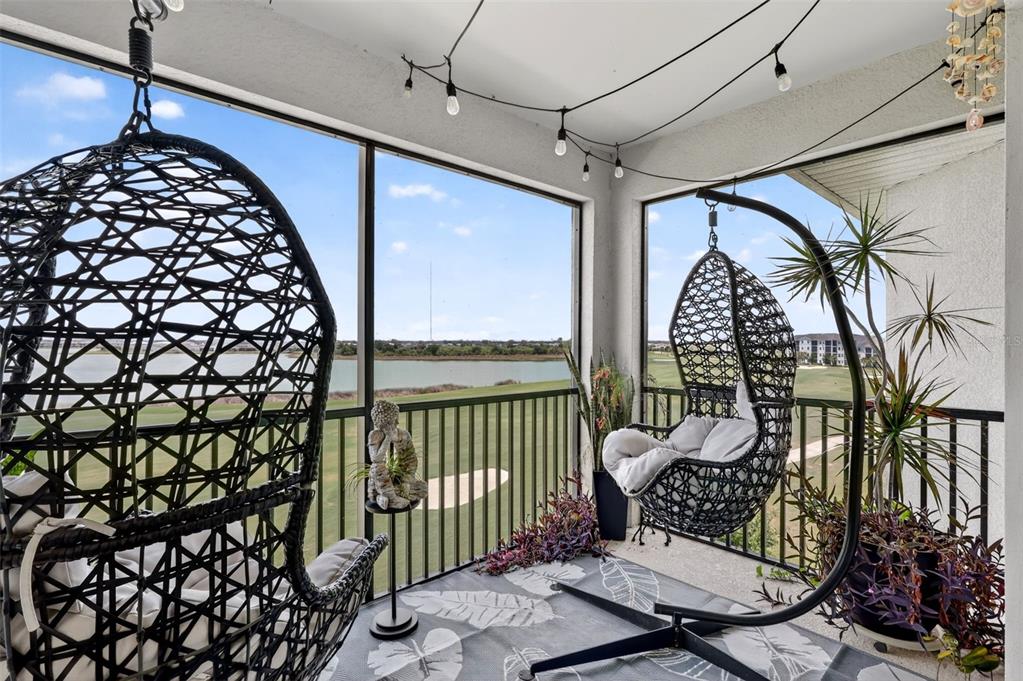 A kitchen with white cabinets, granite countertops, an island with bar stools, and dining area — 43050 GREENWAY BOULEVARD UNIT 645, PUNTA GORDA, FL