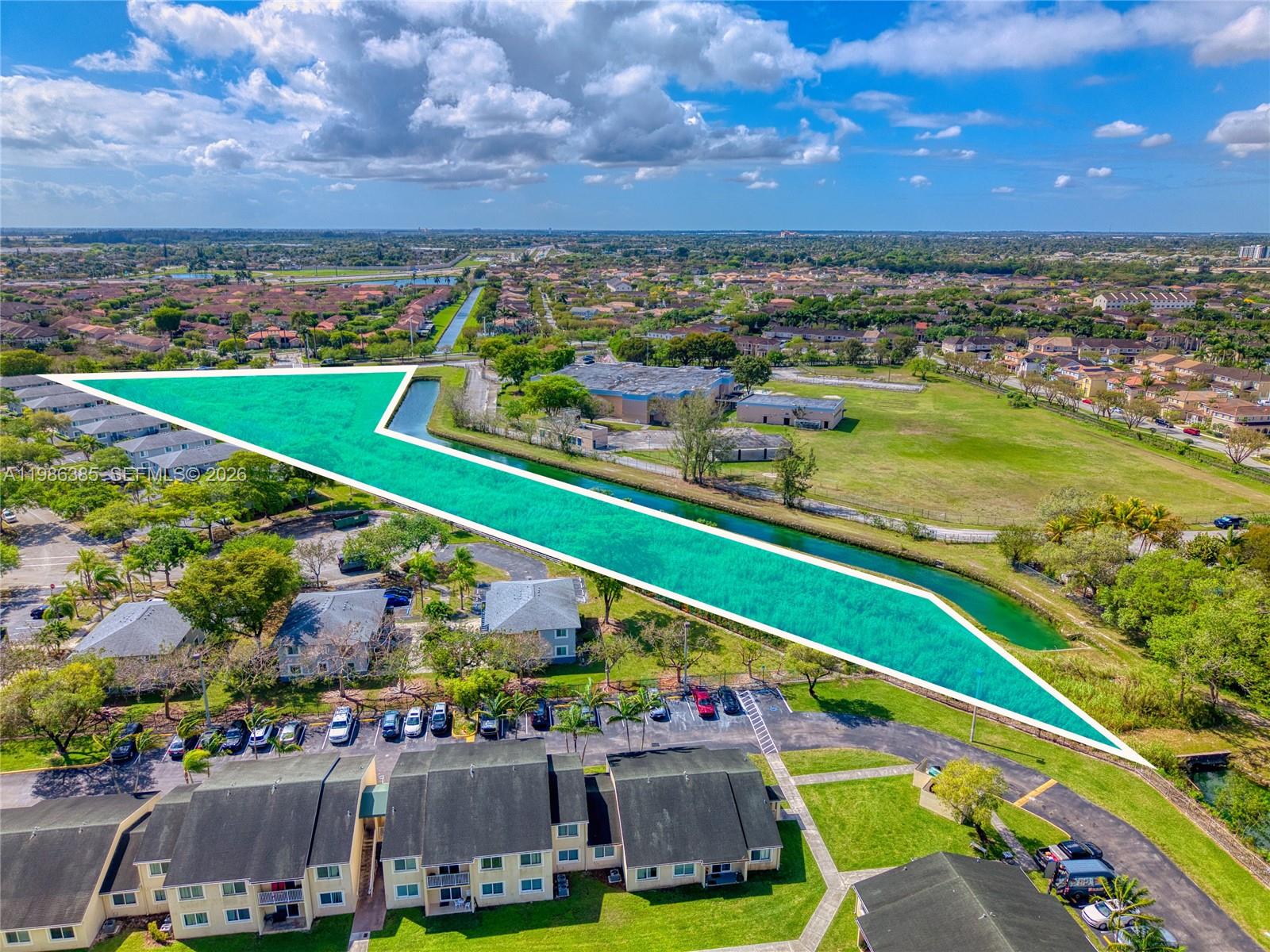 An aerial view highlights a vacant plot of land adjacent to a canal and residential buildings — 139XX SW 272 ST, Naranja FL 33032, NARANJA, FL