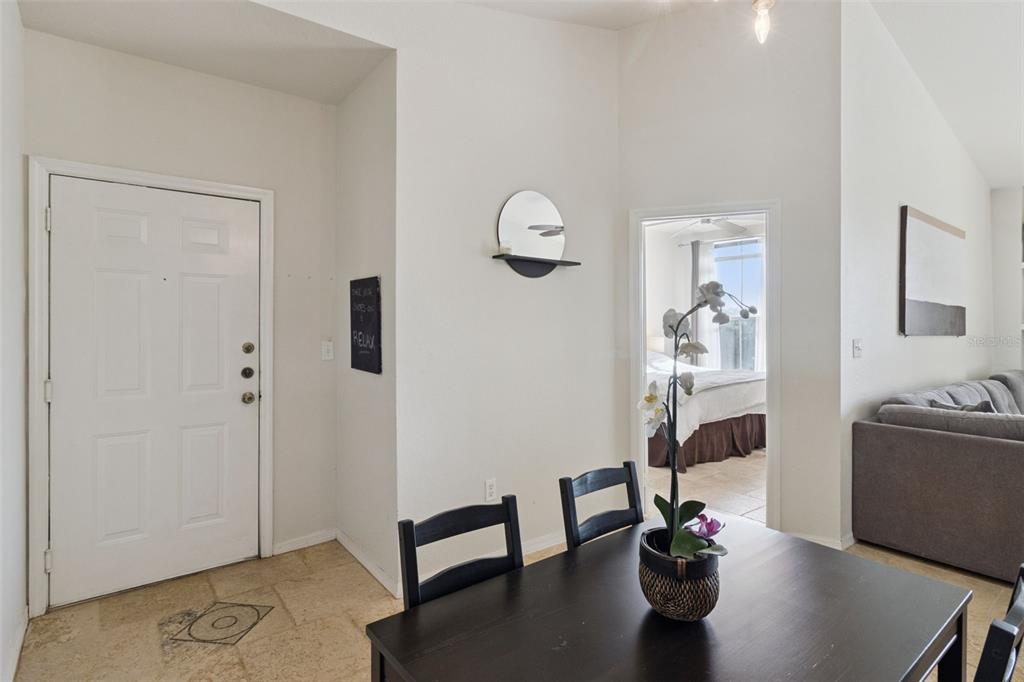A dining area features a dark table, tile flooring, and a doorway leading to a bedroom — 8811 DUNES COURT UNIT 308, KISSIMMEE, FL