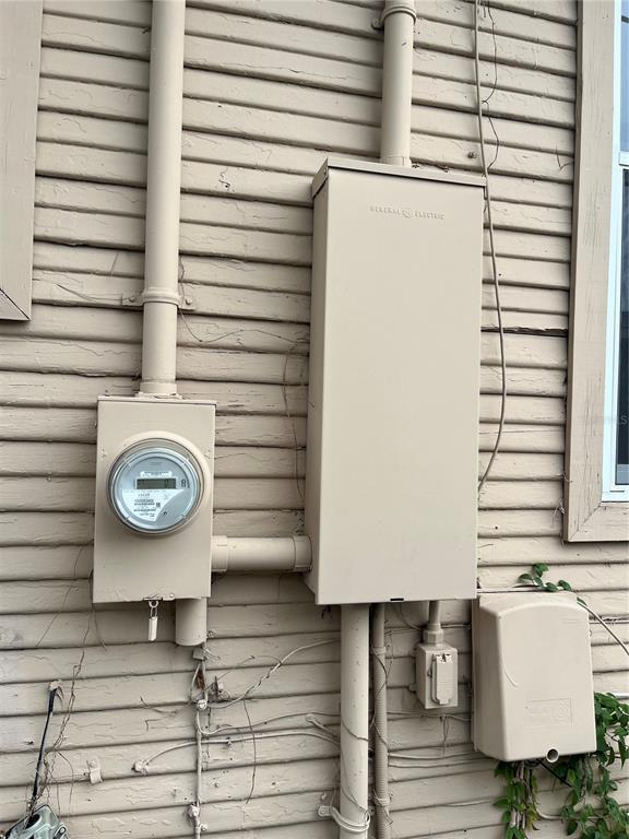An exterior wall features an electrical meter, a large GE service panel, and utility boxes — 201 W IDA STREET, TAMPA, FL