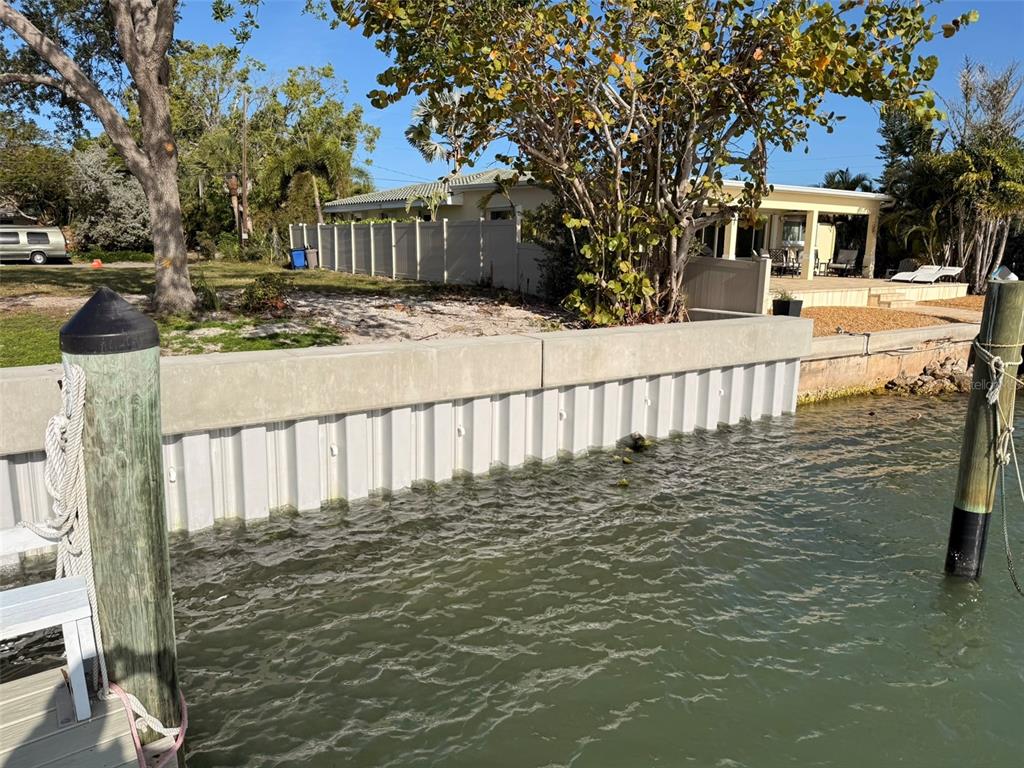 A view of a waterfront property featuring a vinyl seawall and a concrete cap — 4031 POINSETTIA DRIVE, ST PETE BEACH, FL