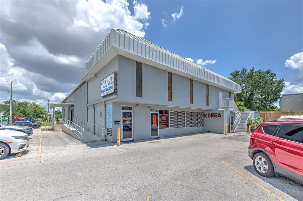 A two-story commercial building with a grey exterior features a Korean restaurant and cafe — 7030 W HILLSBOROUGH AVENUE UNIT Suit B, TAMPA, FL
