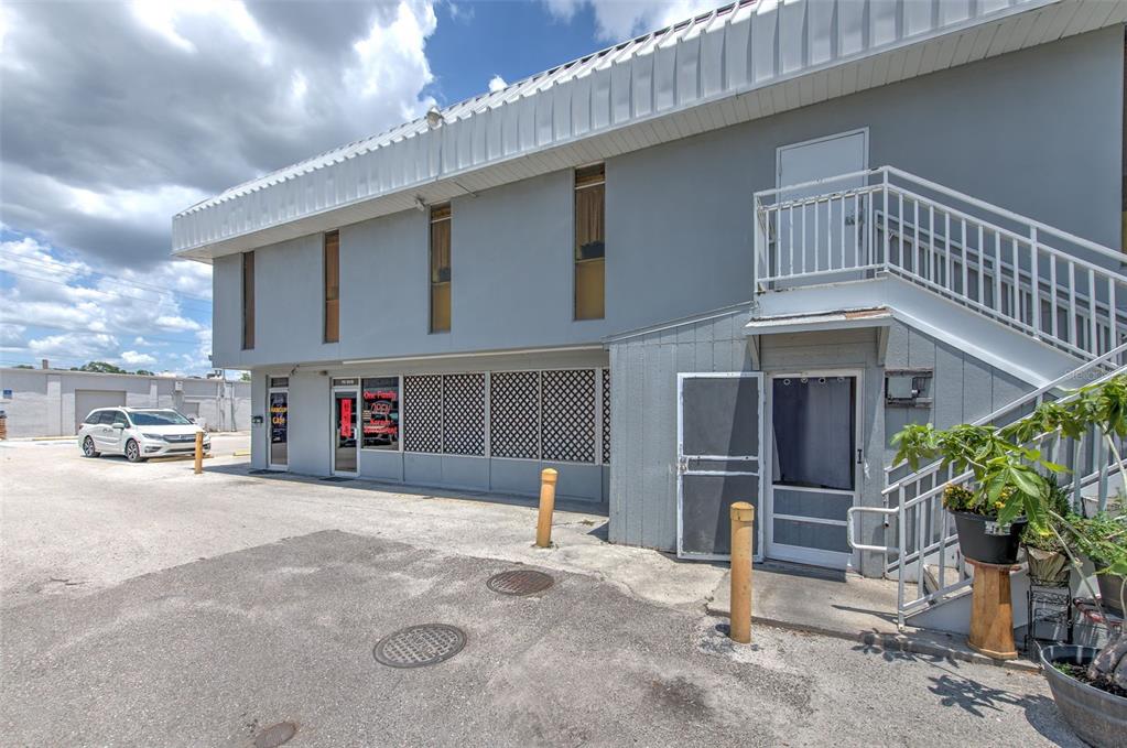 A two-story commercial building with a gray exterior, metal roof, and an outdoor staircase — 7030 W HILLSBOROUGH AVENUE UNIT Suit B, TAMPA, FL
