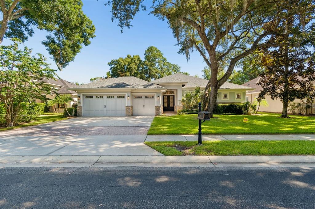 A single-story house with a three-car garage, stone accents, and a large front lawn — 2107 CARROLL LANDING DRIVE, TAMPA, FL