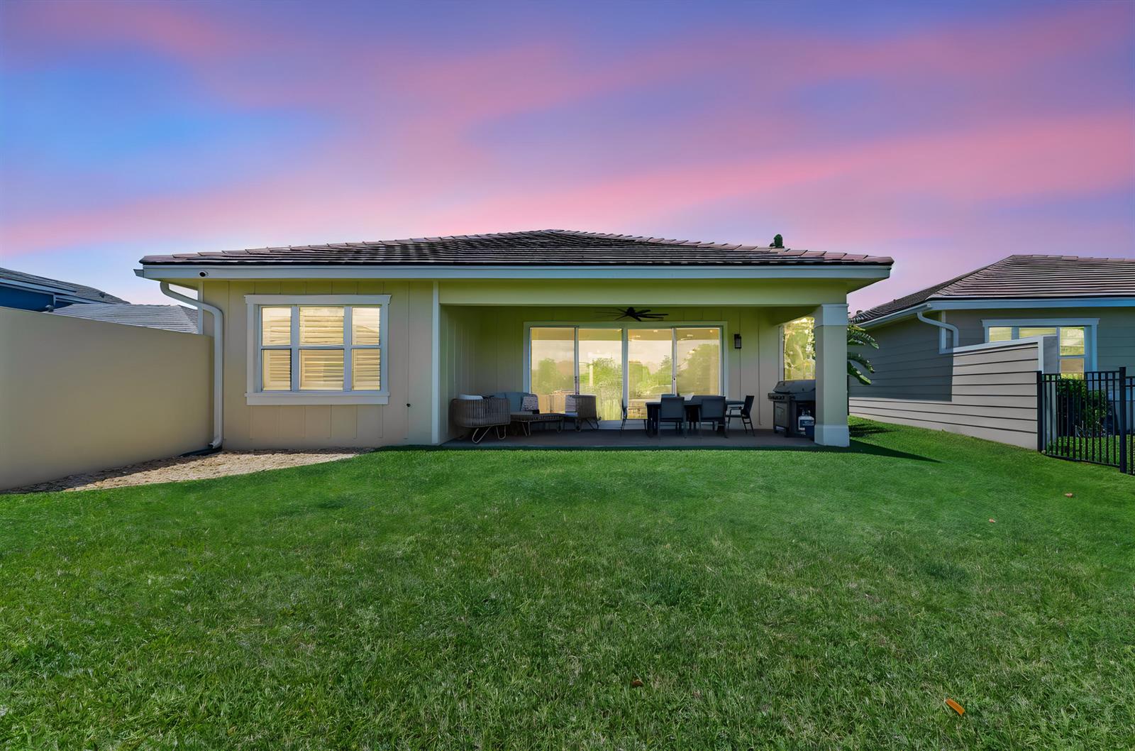 The exterior view shows a house with a covered patio, lawn, and privacy walls — 1338 Harvester Crossing, Loxahatchee FL 33470, LOXAHATCHEE, FL