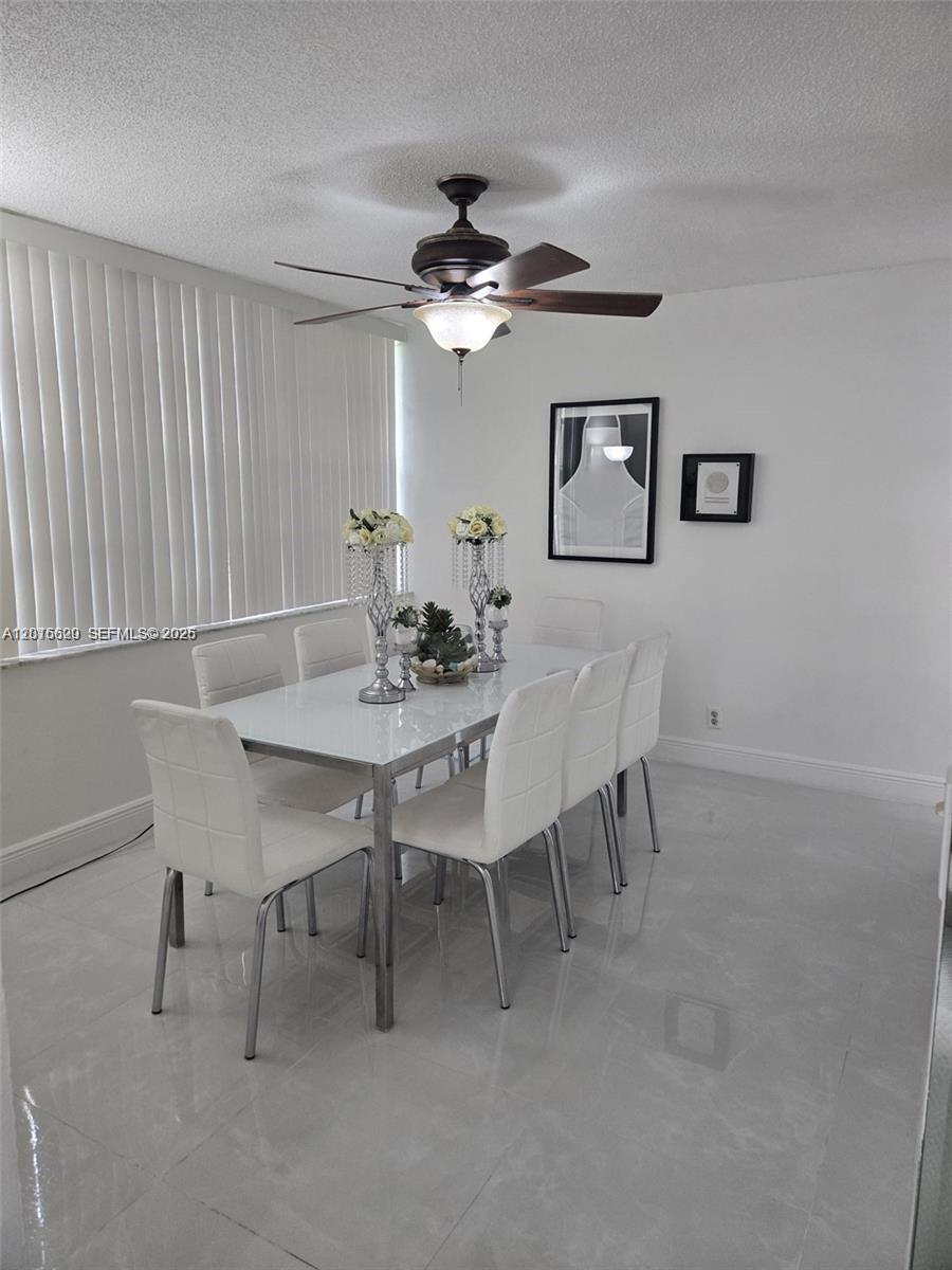 A dining room features a white table, six white chairs, and a ceiling fan — 9410 Live Oak Pl # 103, Davie FL 33324, DAVIE, FL