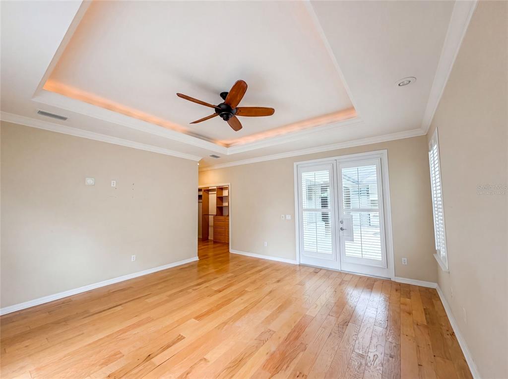 An empty room with hardwood floors, a tray ceiling with recessed lighting, and glass doors — 13478 NW 9TH ROAD, NEWBERRY, FL