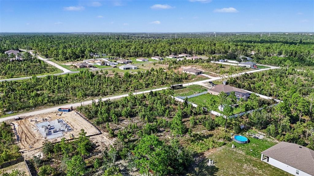An aerial view shows several houses and a construction site surrounded by dense forest — 0 SCISSORBILL AVENUE, WEEKI WACHEE, FL