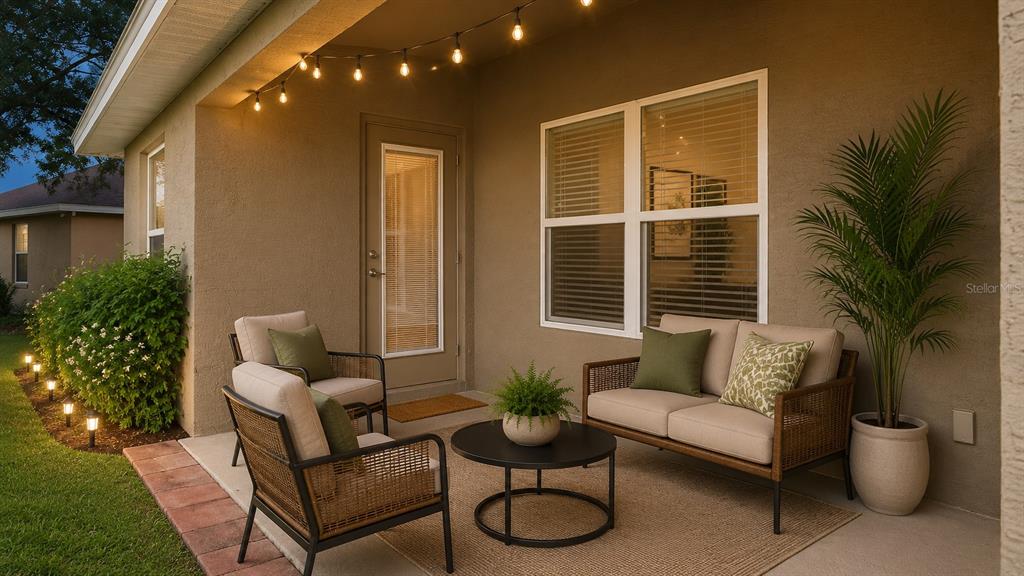 A patio features outdoor furniture, a potted plant, and string lights against a stucco wall — 7172 SHERMAN HILLS BOULEVARD, BROOKSVILLE, FL