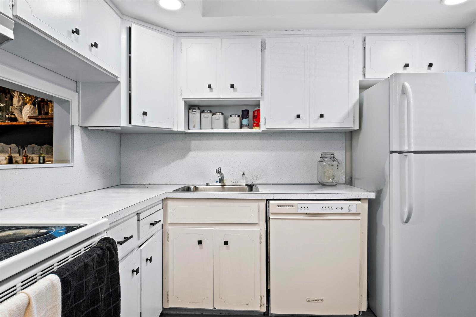 A kitchen features white cabinets, a stainless steel sink, a dishwasher, and a white refrigerator — 899 SE 2nd Avenue # 116, Deerfield Beach FL 33441, DEERFIELD BEACH, FL
