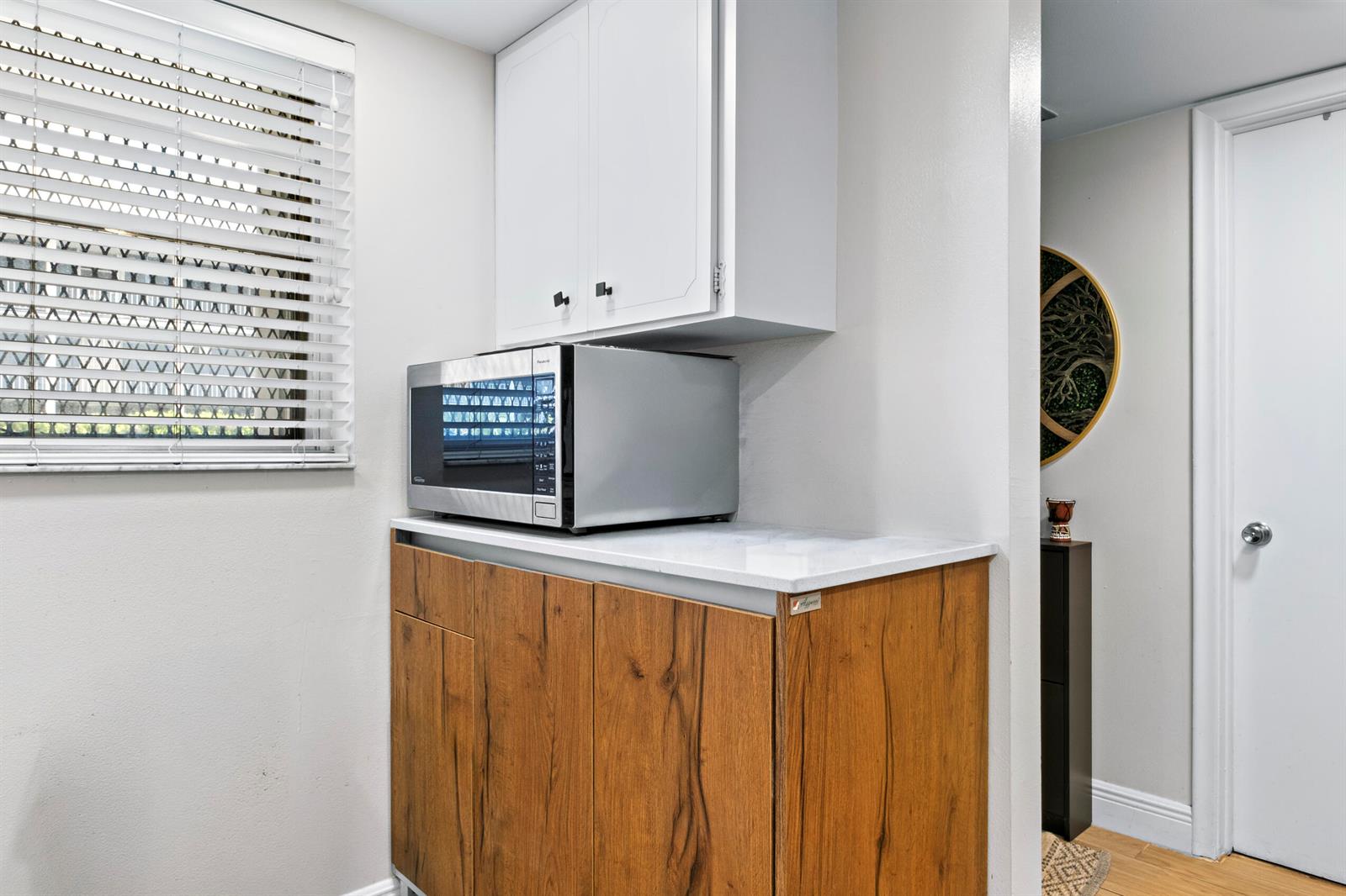 A kitchen area features wood-grain cabinets, a white countertop, and a stainless steel microwave — 899 SE 2nd Avenue # 116, Deerfield Beach FL 33441, DEERFIELD BEACH, FL