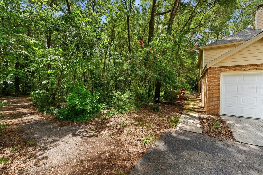 A brick and siding house exterior with a garage and a wooded yard — 5261 SW 97TH DRIVE, GAINESVILLE, FL