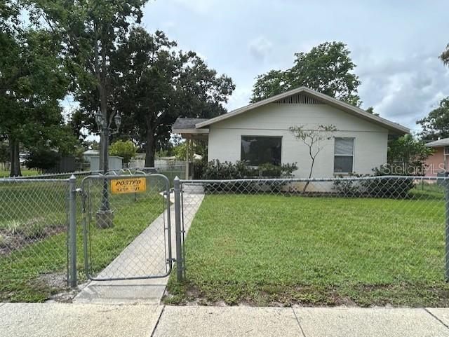 A single-story house with a light-colored exterior sits behind a chain-link fence — 2518 40TH AVENUE N, ST PETERSBURG, FL