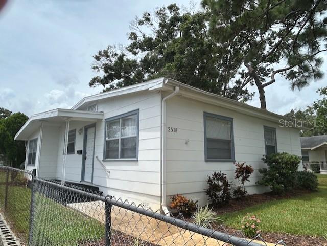 A white, single-story house with a chain-link fence in the foreground — 2518 40TH AVENUE N, ST PETERSBURG, FL