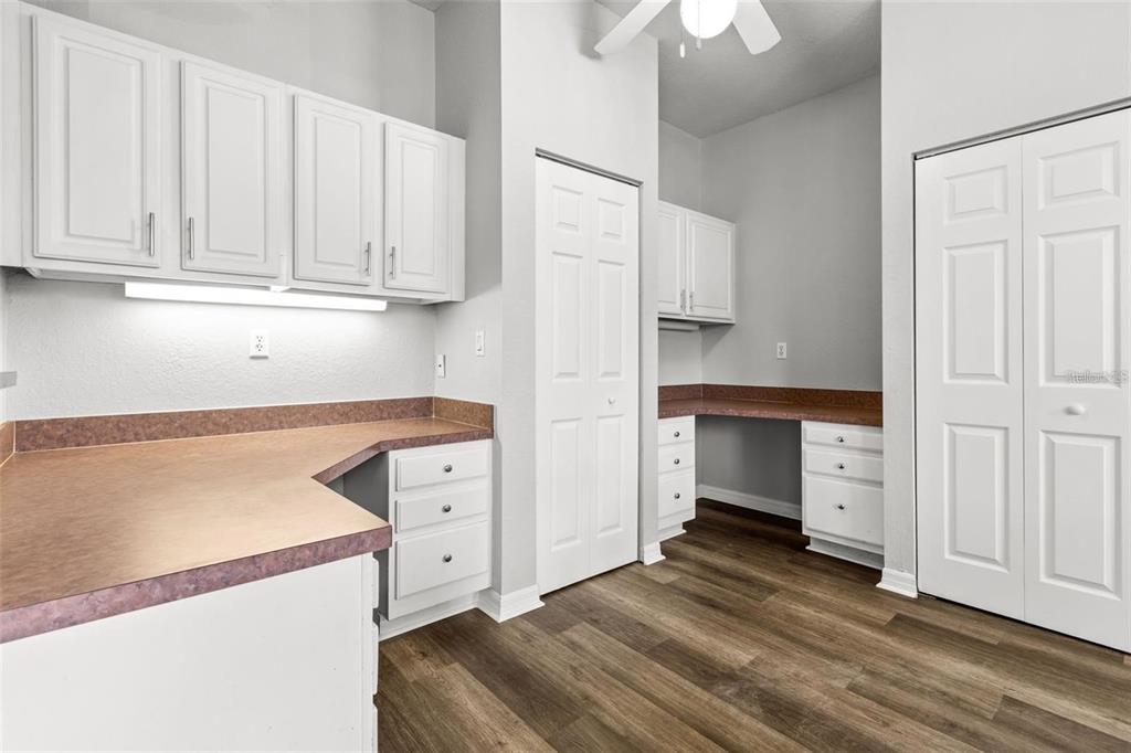 A laundry room with white cabinets, brown countertops, and wood-look flooring — 5009 SUNRIDGE PALMS DRIVE UNIT 203, TAMPA, FL