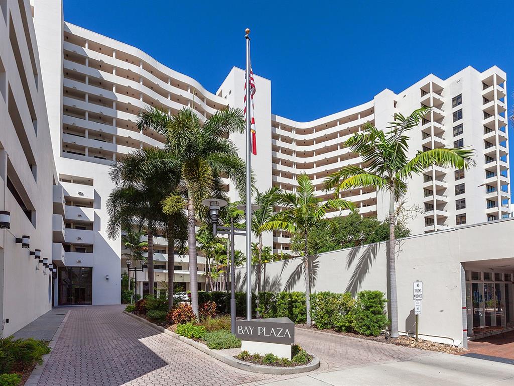The exterior of the white Bay Plaza building features a paved driveway and palm trees — 1255 N GULFSTREAM AVENUE UNIT 205, SARASOTA, FL