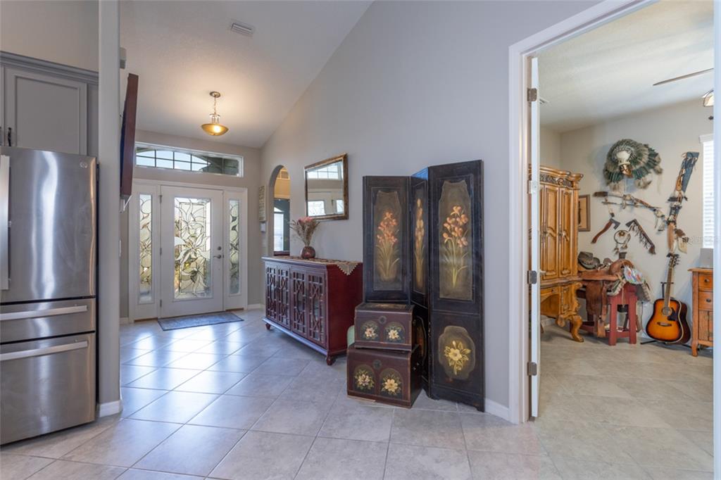 A tiled entryway features a front door with glass inserts, a wooden console, and a screen — 43 LAGOON WAY, PALM COAST, FL