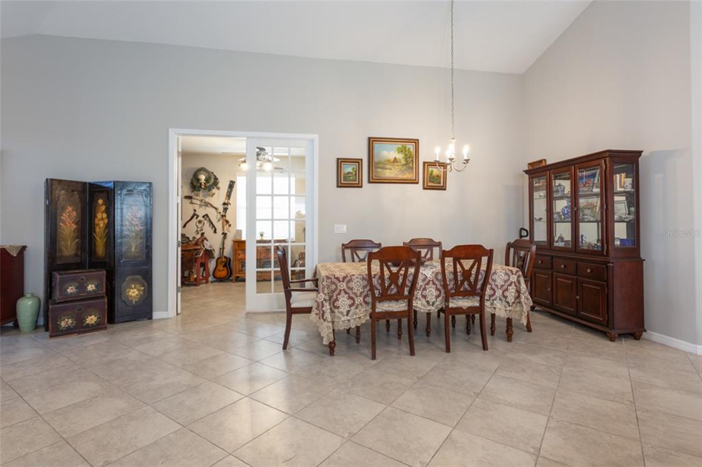 A dining room features tile flooring, a wooden table with chairs, and a china cabinet — 43 LAGOON WAY, PALM COAST, FL