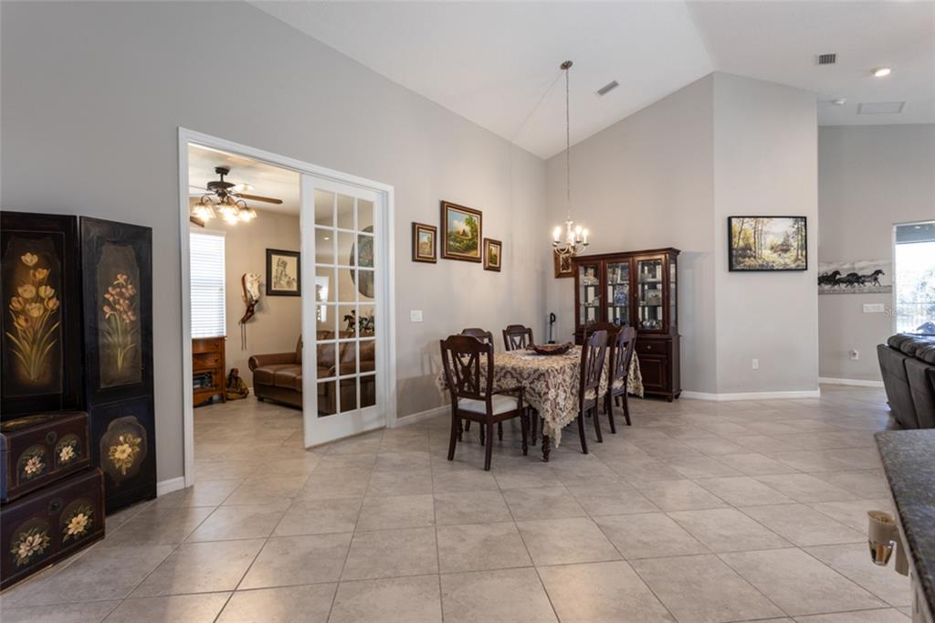 A dining room with a table and chairs sits adjacent to a room with French doors — 43 LAGOON WAY, PALM COAST, FL