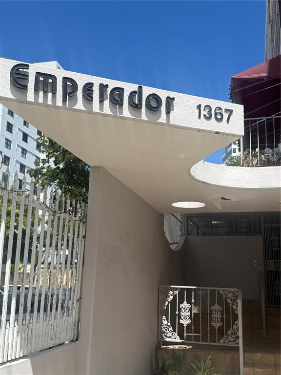 The exterior entrance of a building features a white concrete overhang with black lettering — 1367 WILSON UNIT 401, SAN JUAN, PR