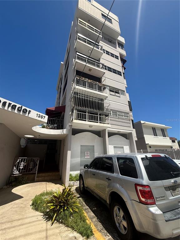 A multi-story apartment building with balconies and a silver SUV parked in front — 1367 WILSON UNIT 401, SAN JUAN, PR