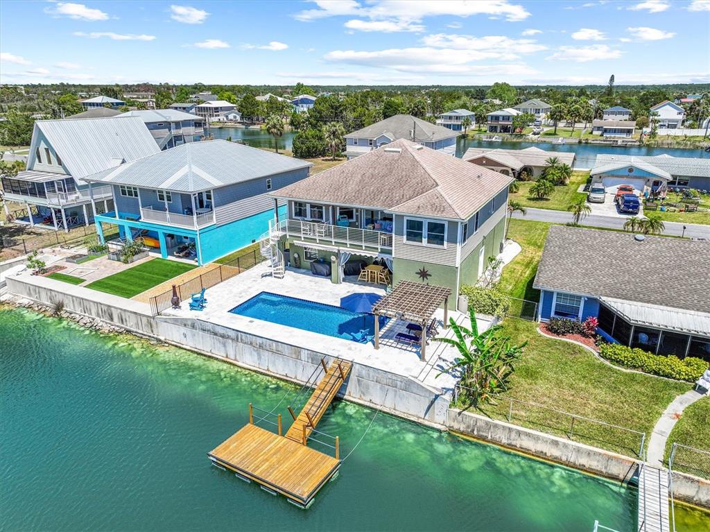 An aerial view of a waterfront house featuring a swimming pool, patio, and wooden dock — 3351 POINSETTIA DRIVE, HERNANDO BEACH, FL