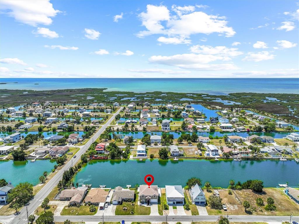 An aerial view shows a waterfront house with a red location pin on a canal — 3351 POINSETTIA DRIVE, HERNANDO BEACH, FL